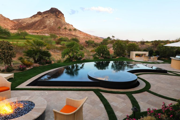 Hot tub - contemporary backyard stone and custom-shaped infinity hot tub idea in Las Vegas
