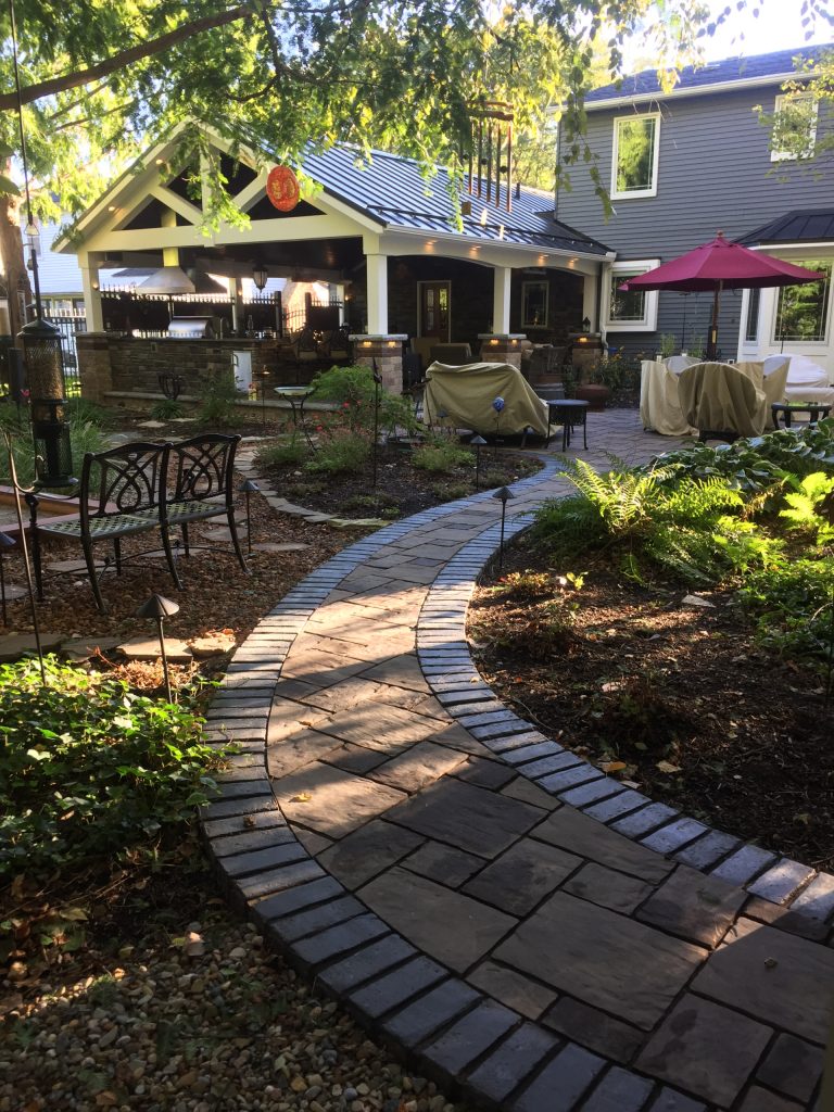 Huge arts and crafts backyard brick patio kitchen photo in Cleveland with a roof extension