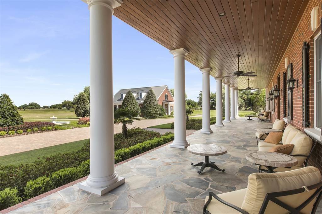 Huge elegant stone back porch photo in Orlando with a roof extension by Canin Associates' Architecture Studio | Outdoor Photos | Porch | Landscaping | Landscape Design | Outdoor Living Space | Porch Design Ideas | Outdoor Living Space Ideas | Backyard Design