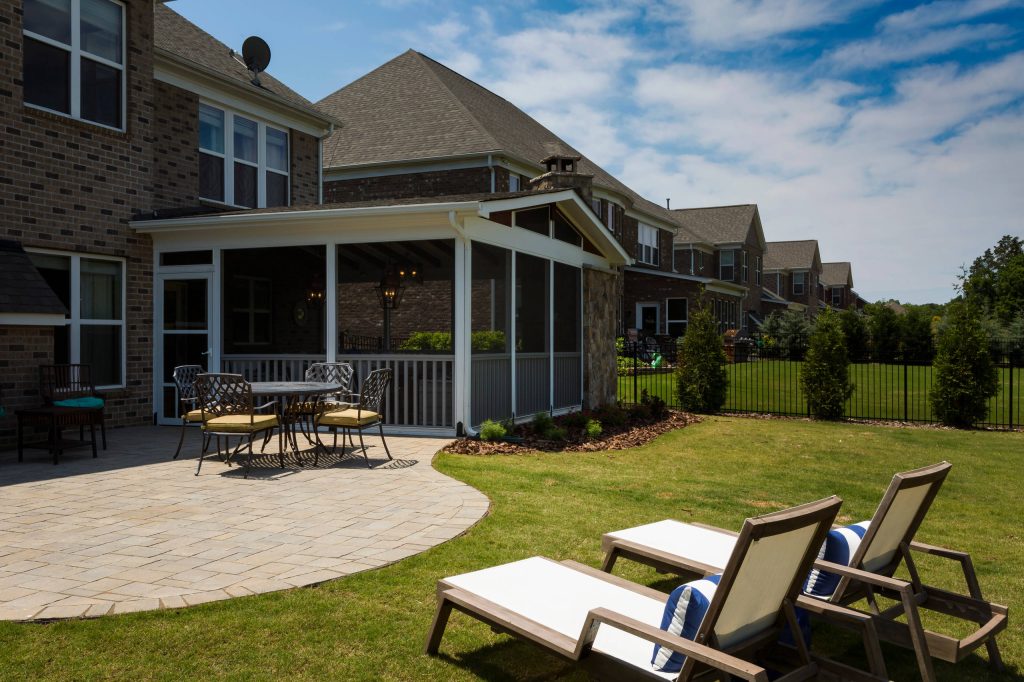 Huge farmhouse concrete paver screened-in back porch idea in Charlotte with a roof extension by The Stone Man | Outdoor Photos | Porch | Landscaping | Landscape Design | Outdoor Living Space | Porch Design Ideas | Outdoor Living Space Ideas | Backyard Design