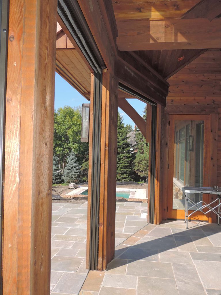 Huge mountain style stone screened-in back porch idea in Minneapolis with a roof extension by Minnesota Screens | Outdoor Photos | Porch | Landscaping | Landscape Design | Outdoor Living Space | Porch Design Ideas | Outdoor Living Space Ideas | Backyard Design