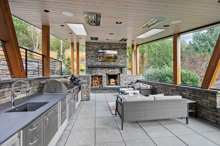 Huge side yard concrete patio kitchen photo in Seattle with a roof extension