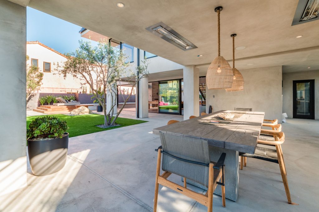 Huge trendy backyard concrete patio kitchen photo in Los Angeles with a roof extension