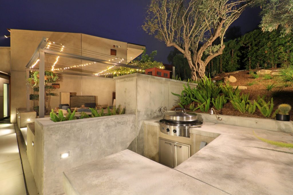 Huge trendy backyard concrete paver patio kitchen photo in Orange County with no cover