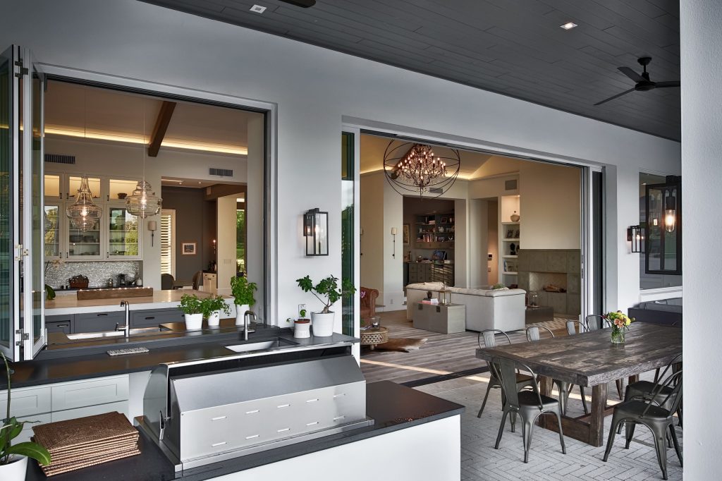 Huge trendy backyard patio kitchen photo in Orlando with a roof extension