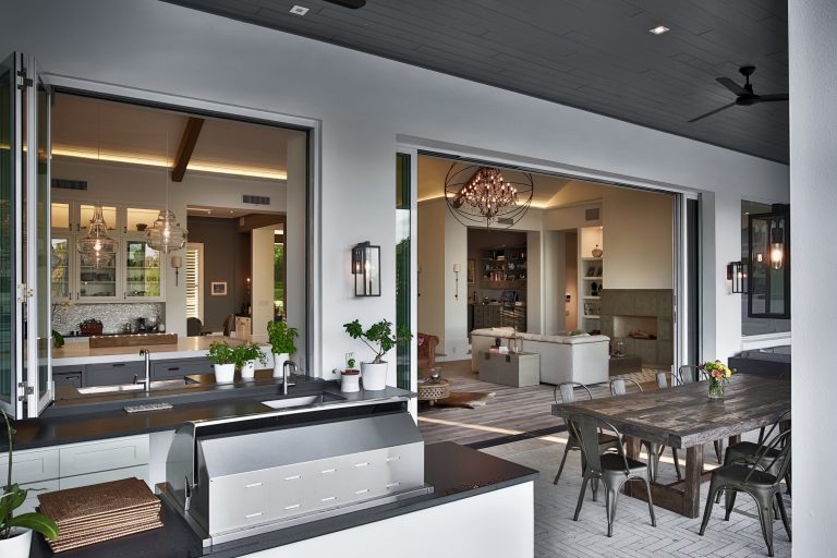 Huge trendy backyard patio kitchen photo in Orlando with a roof extension