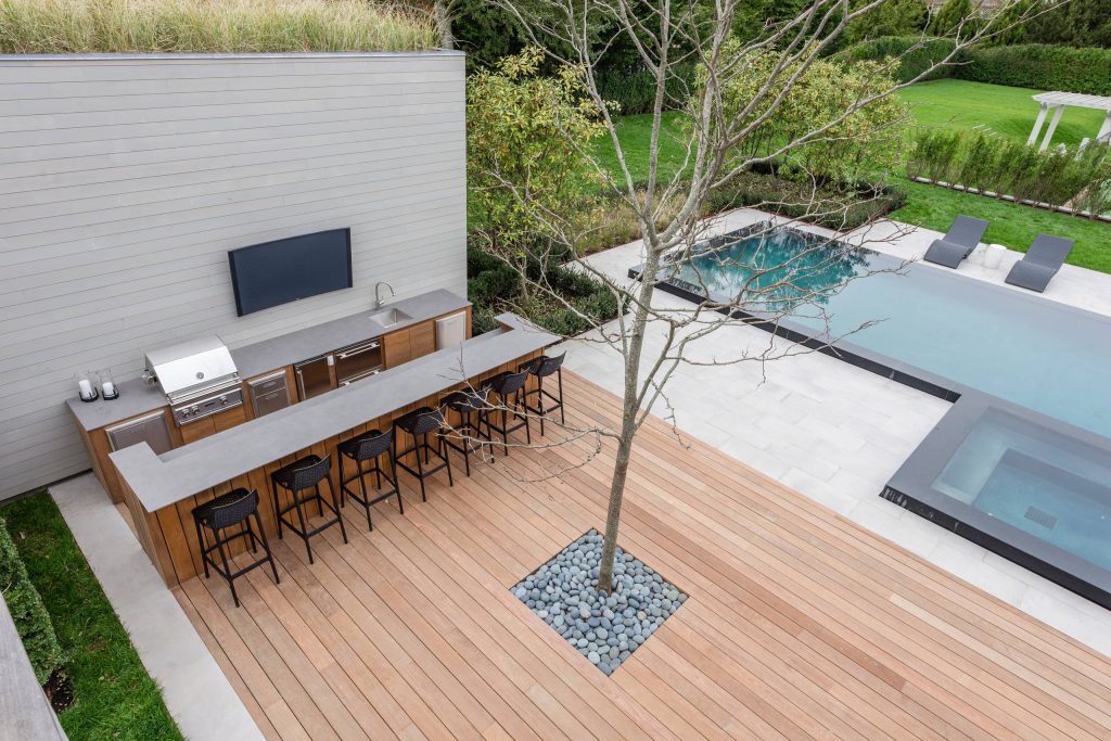 Huge trendy backyard tile and custom-shaped infinity pool house photo in New York