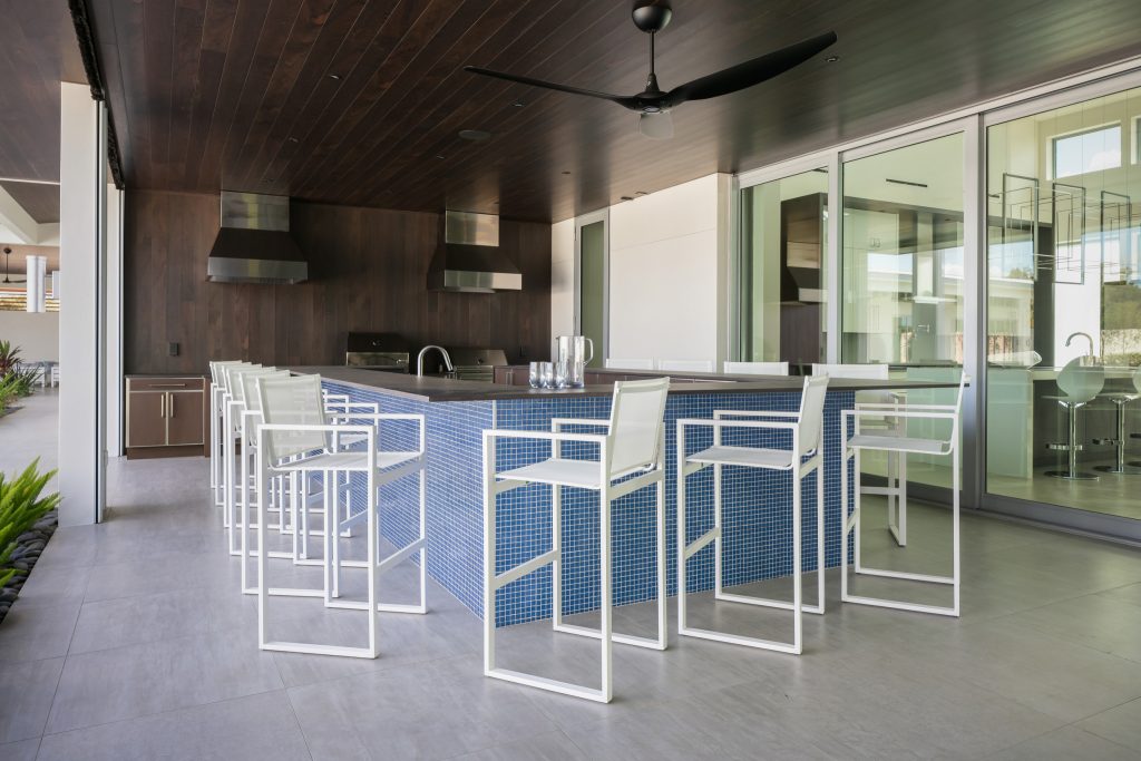 Huge trendy courtyard tile patio kitchen photo in Tampa with a roof extension