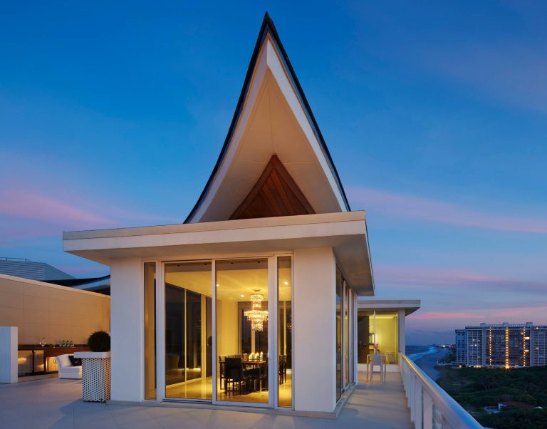Huge trendy outdoor kitchen deck photo in Miami with a roof extension