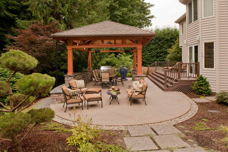 Imported soil and crushed rock raised far end of patio 4' from existing sloped lawn.