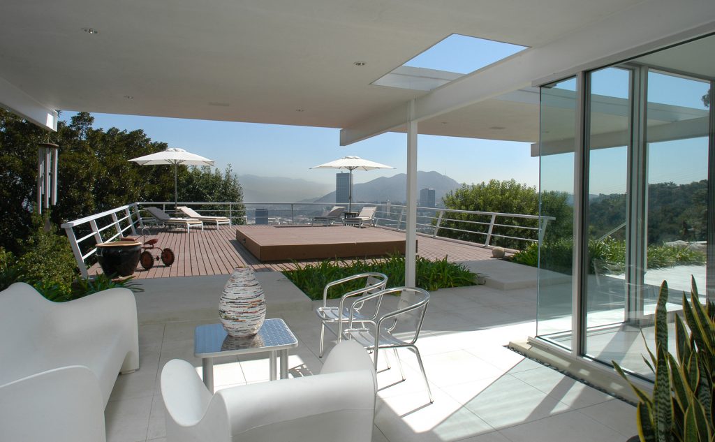 Indoor-outdoor living space with twin bridges to cantilevered wood deck.