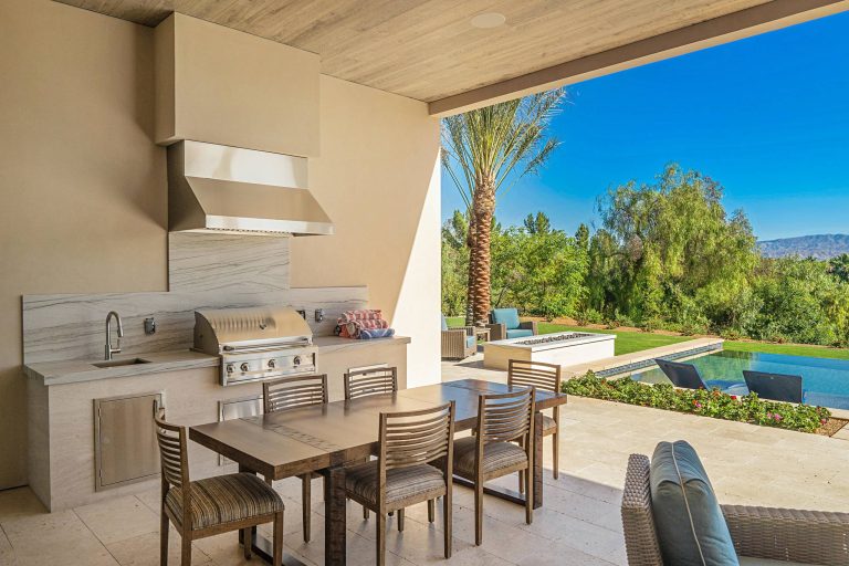 Inspiration for a contemporary backyard patio kitchen remodel in Orange County with a roof extension
