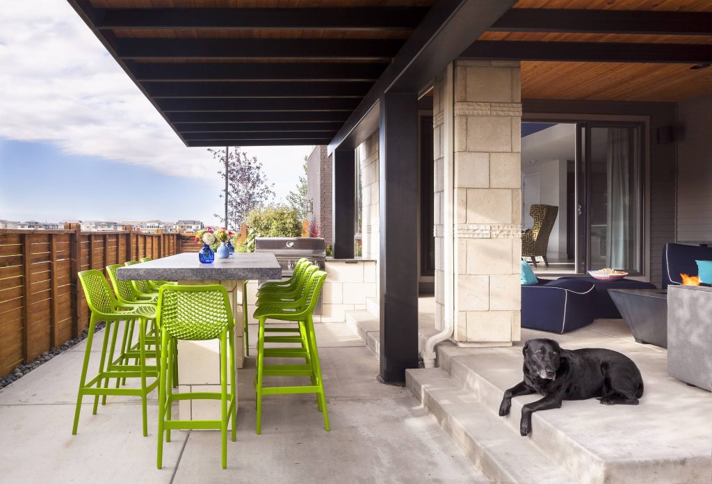 Inspiration for a contemporary concrete patio kitchen remodel in Denver with a roof extension