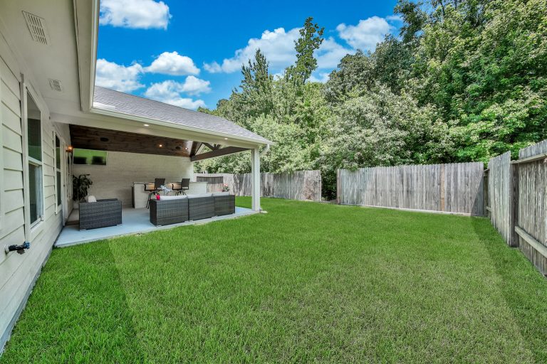 Inspiration for a contemporary concrete patio kitchen remodel in Houston with a roof extension