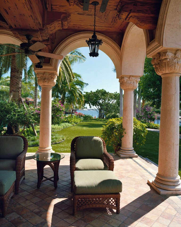 Inspiration for a huge mediterranean stone back porch remodel in Miami with a roof extension by Marker Construction Group | Outdoor Photos | Porch | Landscaping | Landscape Design | Outdoor Living Space | Porch Design Ideas | Outdoor Living Space Ideas | Backyard Design