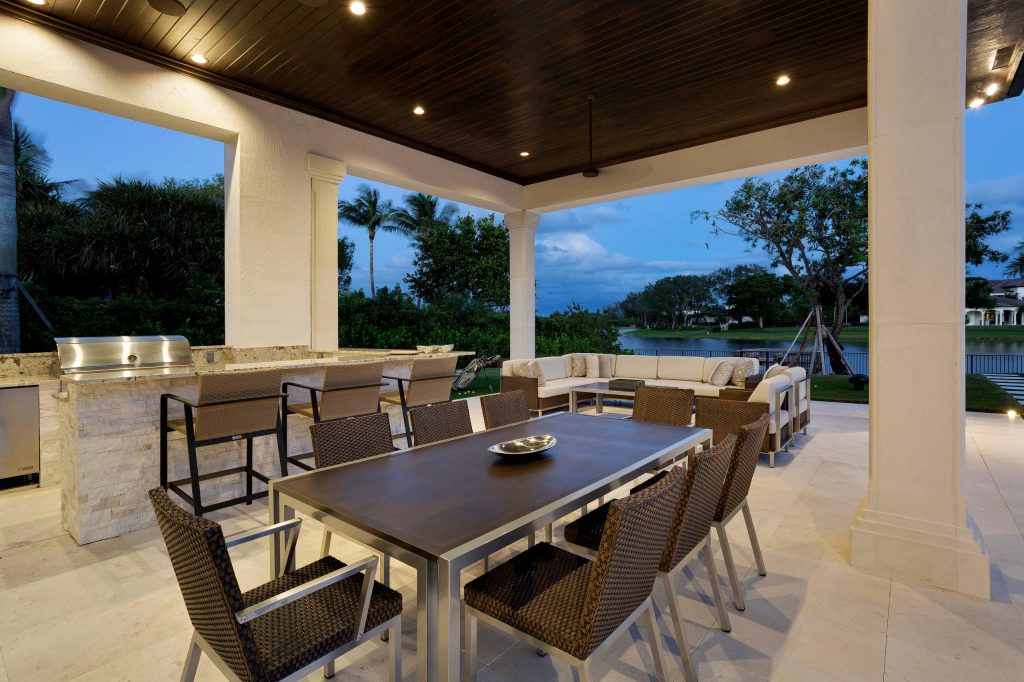 Inspiration for a huge transitional backyard stone patio kitchen remodel in Miami with a roof extension