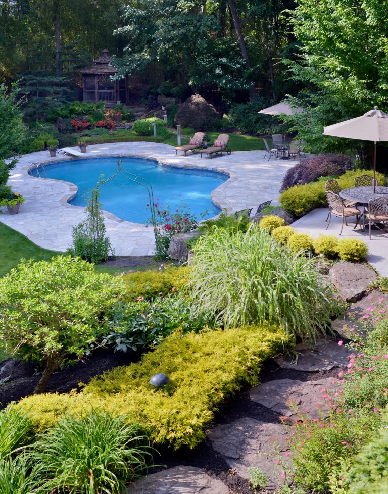 Inspiration for a large 1960s backyard stone and custom-shaped natural pool remodel in New York