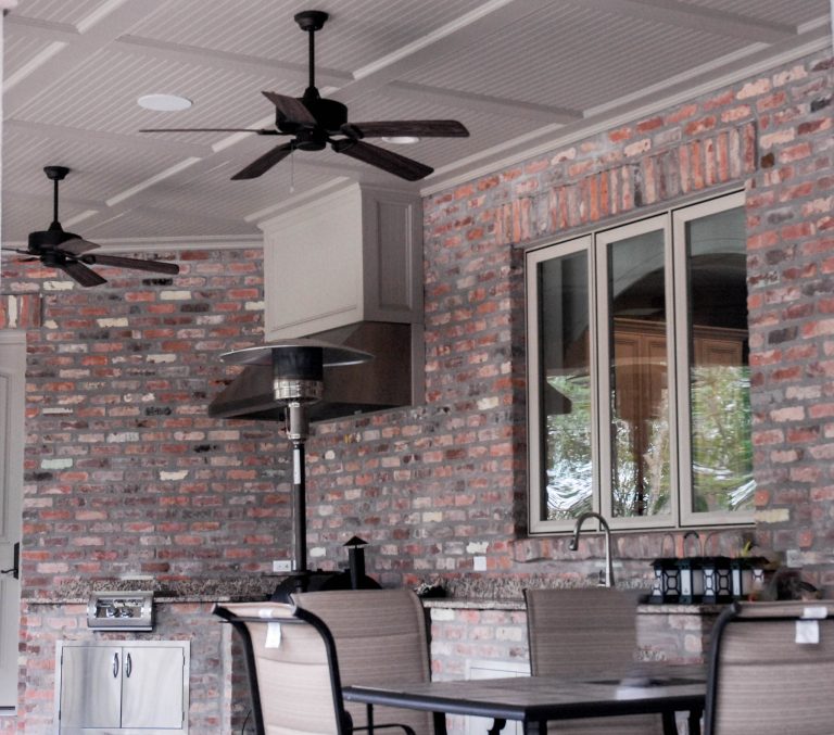 Inspiration for a large backyard concrete patio kitchen remodel in New Orleans with a roof extension