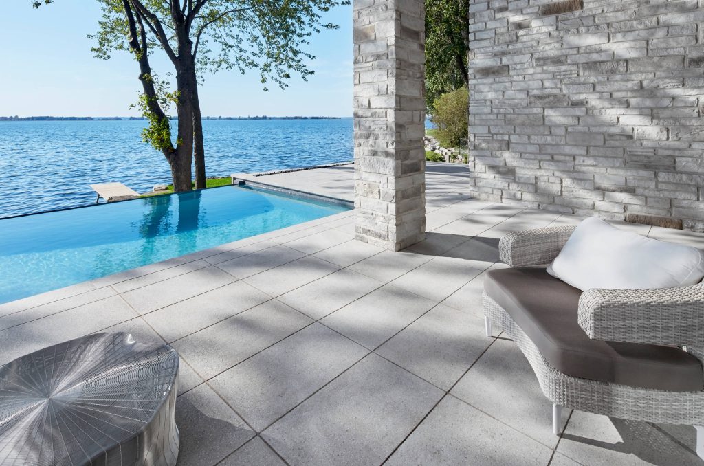 Inspiration for a large backyard concrete paver and rectangular infinity pool remodel in Philadelphia