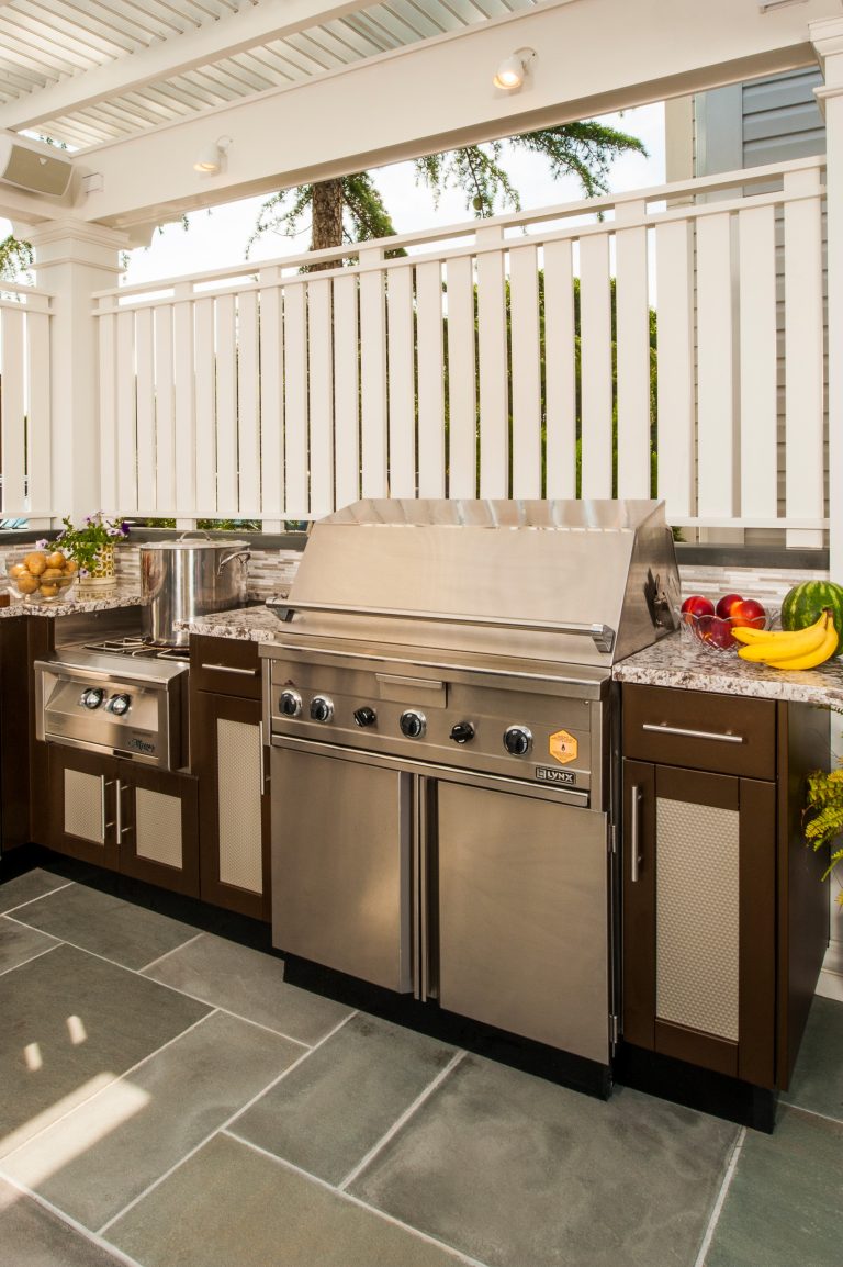 Inspiration for a large contemporary backyard brick patio kitchen remodel in New York with an awning