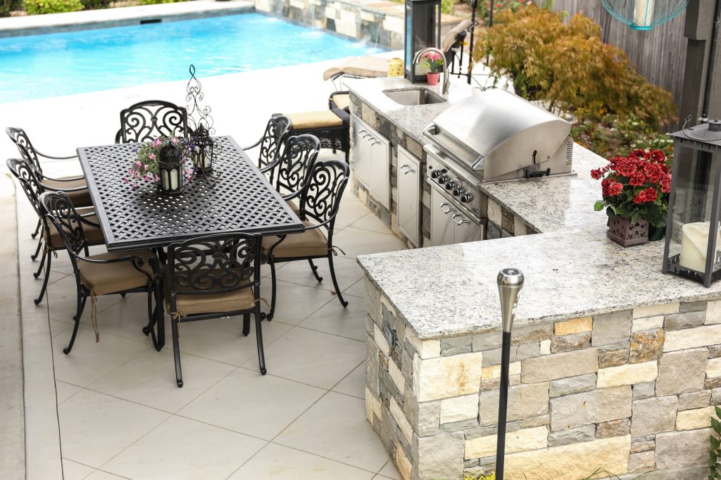 Inspiration for a large contemporary backyard concrete patio kitchen remodel in Other with a pergola