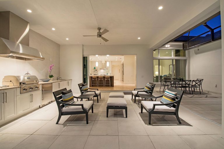 Inspiration for a large contemporary backyard concrete paver patio kitchen remodel in Miami with a roof extension