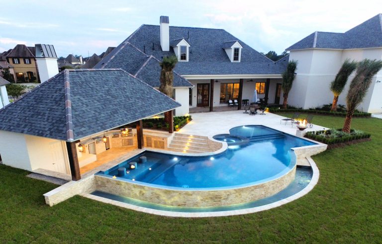 Inspiration for a large contemporary backyard custom-shaped infinity pool house remodel in New Orleans with decking