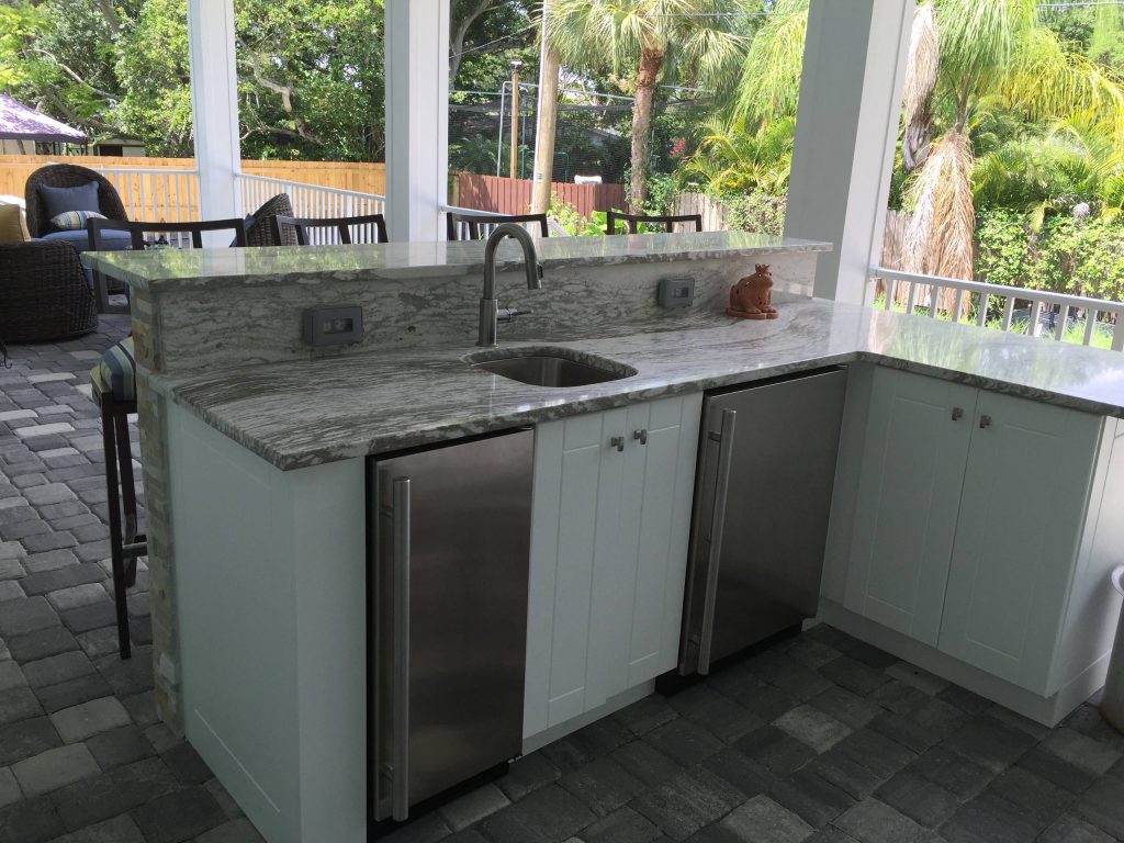 Inspiration for a large contemporary backyard patio kitchen remodel in Tampa with a roof extension