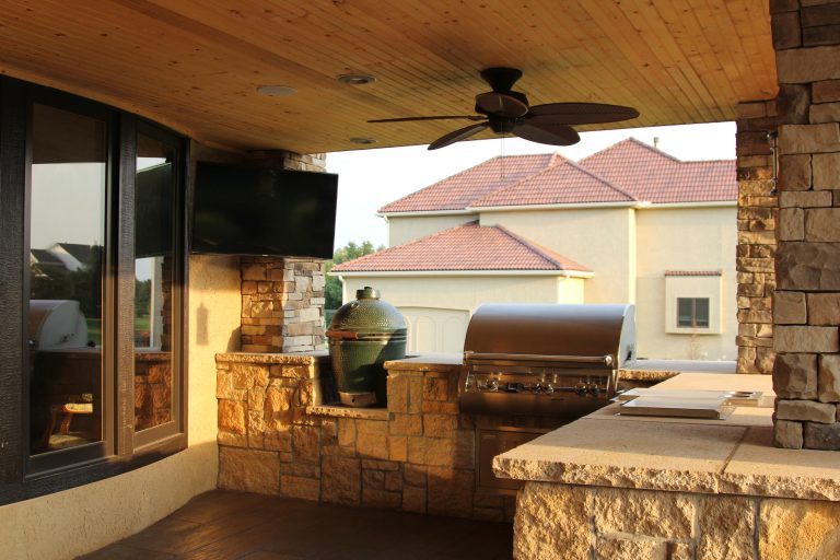 Inspiration for a large contemporary backyard stamped concrete patio kitchen remodel in Kansas City with a roof extension