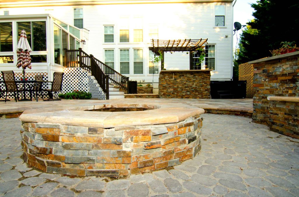 Inspiration for a large contemporary backyard stone patio kitchen remodel in Baltimore with a pergola