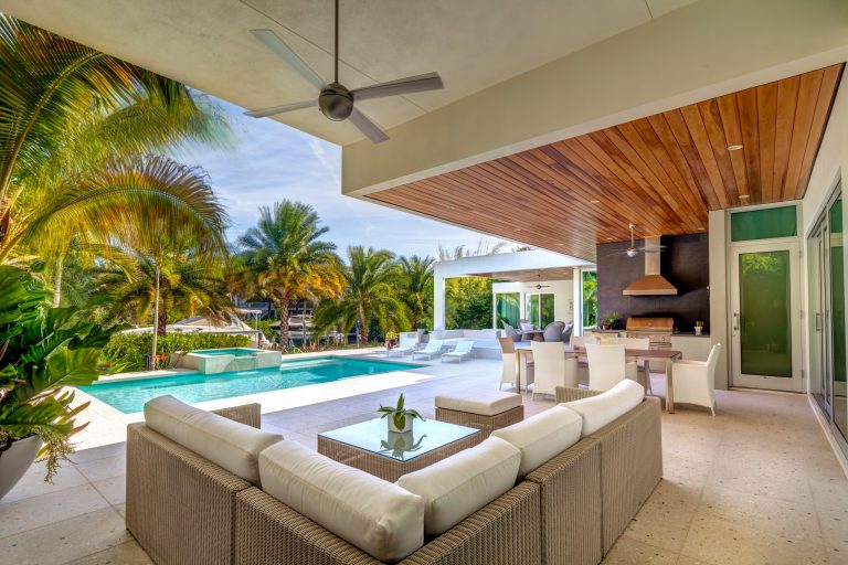 Inspiration for a large contemporary backyard stone patio kitchen remodel in Tampa with a roof extension
