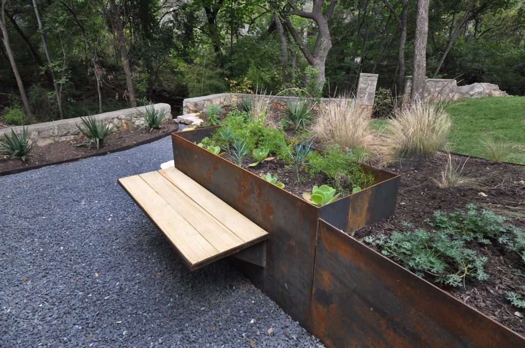 Inspiration for a large contemporary drought-tolerant and partial sun backyard gravel retaining wall landscape in Austin.