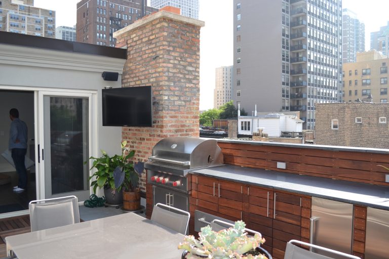 Inspiration for a large contemporary rooftop outdoor kitchen deck remodel in Chicago with a pergola