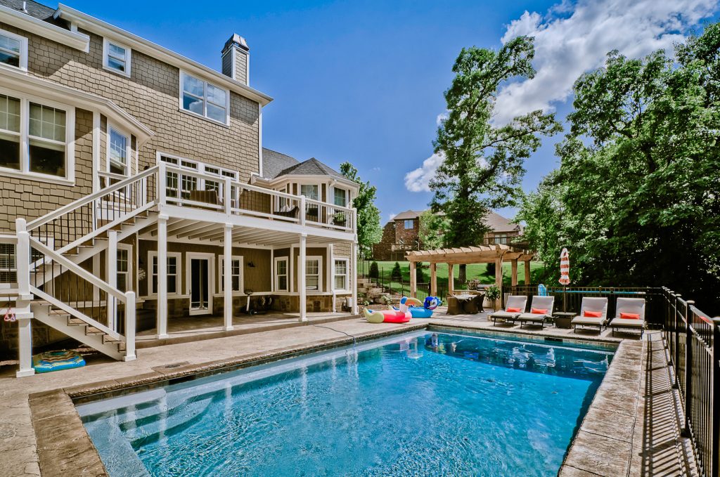 Inspiration for a large craftsman backyard stamped concrete and rectangular pool remodel in Other