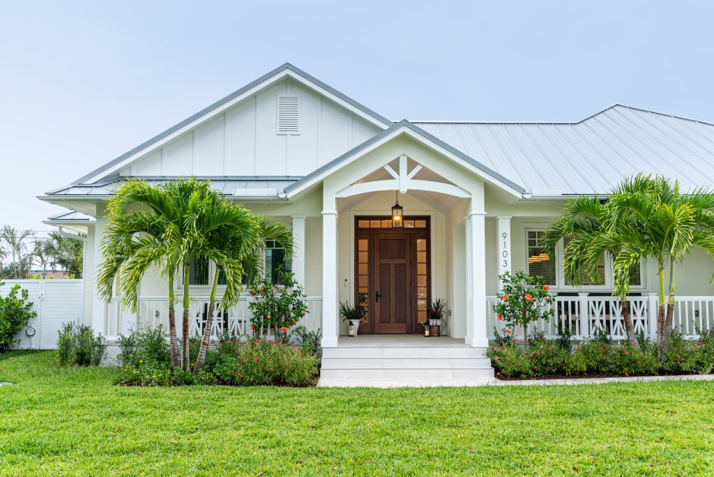 Inspiration for a large farmhouse tile wood railing porch remodel in Miami with a roof extension by Vogl Architects | Outdoor Photos | Porch | Landscaping | Landscape Design | Outdoor Living Space | Porch Design Ideas | Outdoor Living Space Ideas | Backyard Design