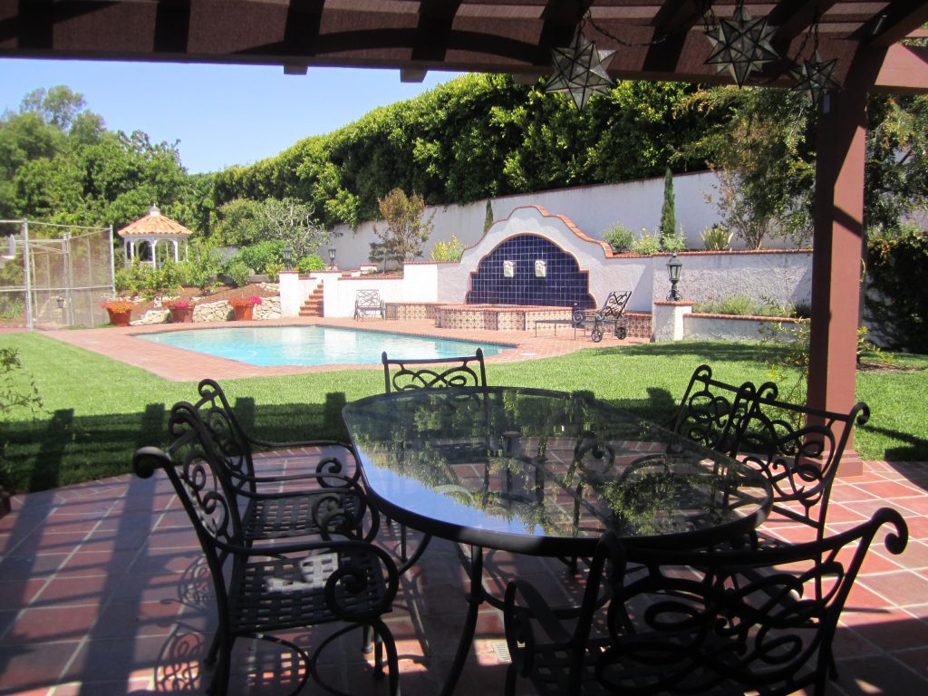 Inspiration for a large mediterranean backyard tile patio kitchen remodel in Los Angeles with a pergola