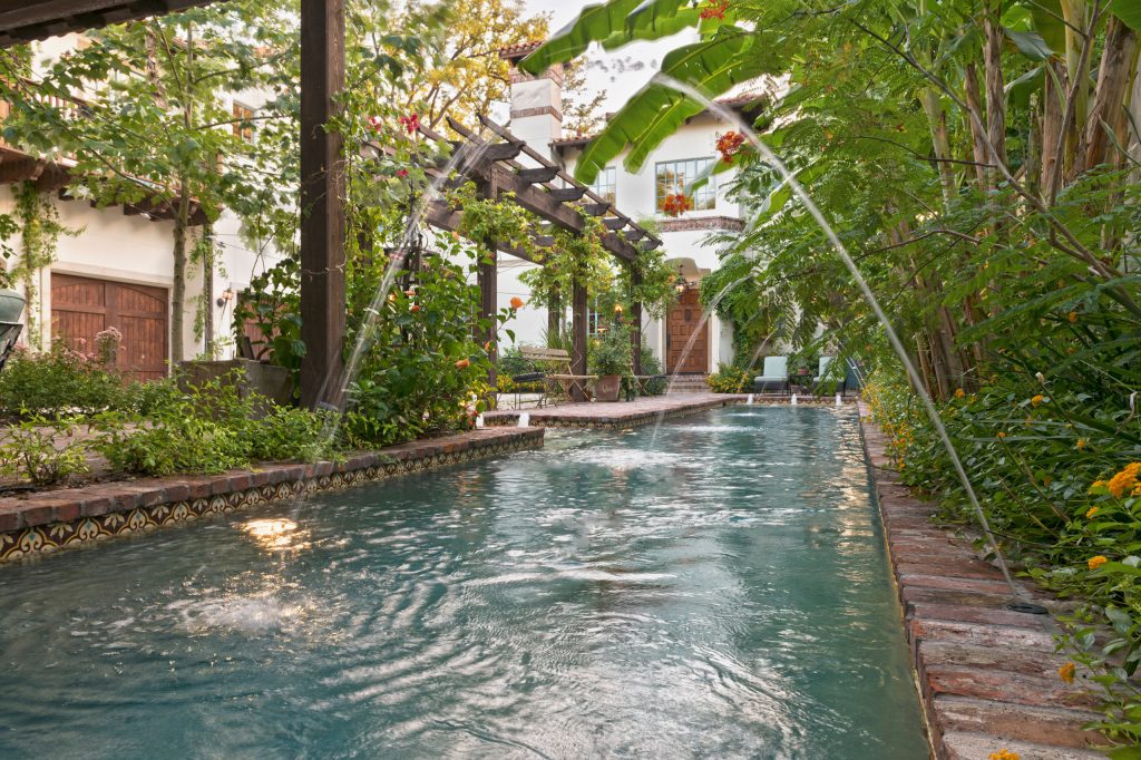 Inspiration for a large mediterranean side yard brick and rectangular lap pool fountain remodel in Houston