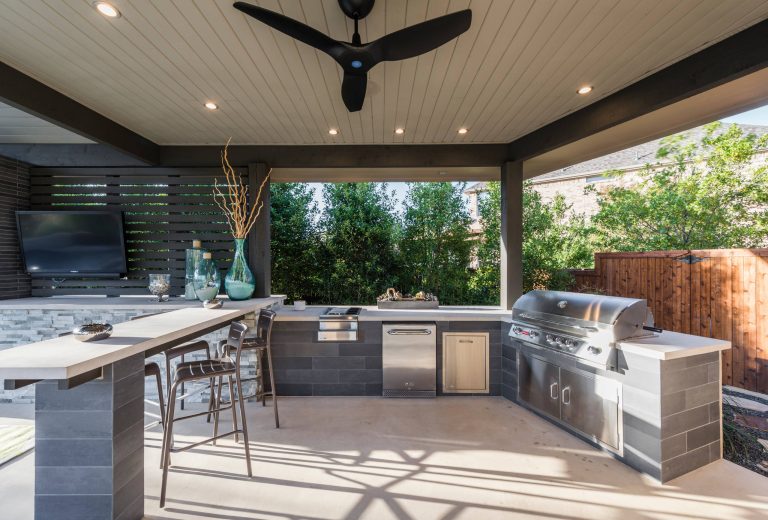 Inspiration for a large modern backyard concrete patio kitchen remodel in Dallas with a roof extension