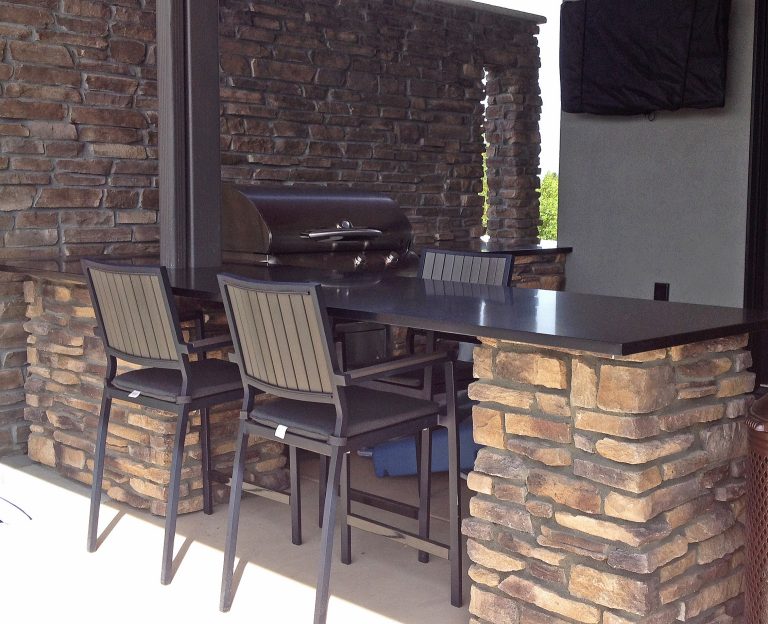 Inspiration for a large modern backyard concrete paver patio kitchen remodel in Denver with a roof extension