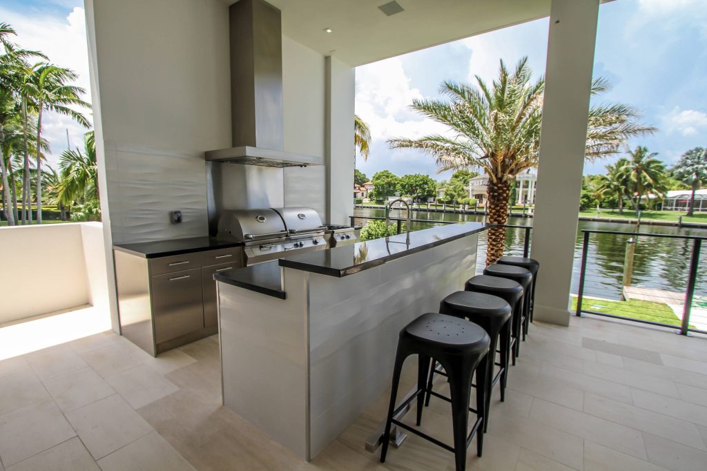 Inspiration for a large modern backyard patio kitchen remodel in Miami with a roof extension