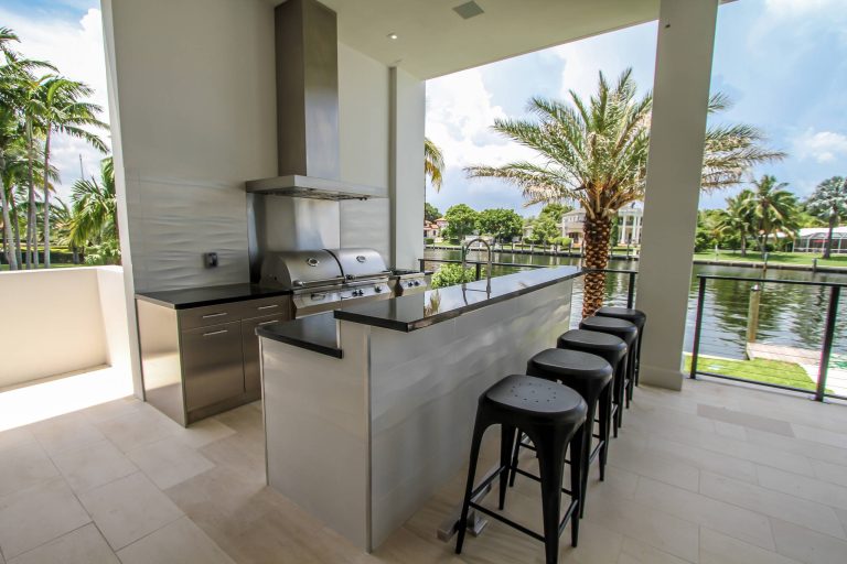 Inspiration for a large modern backyard patio kitchen remodel in Miami with a roof extension