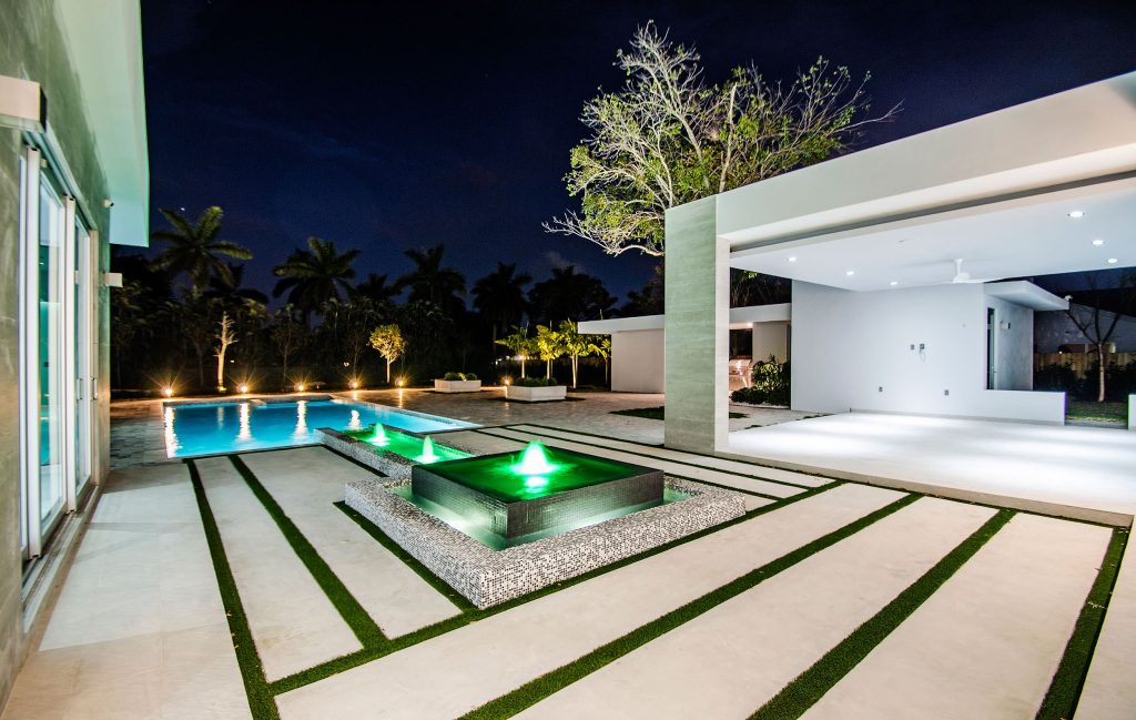 Inspiration for a large modern backyard tile and rectangular lap pool fountain remodel in Miami