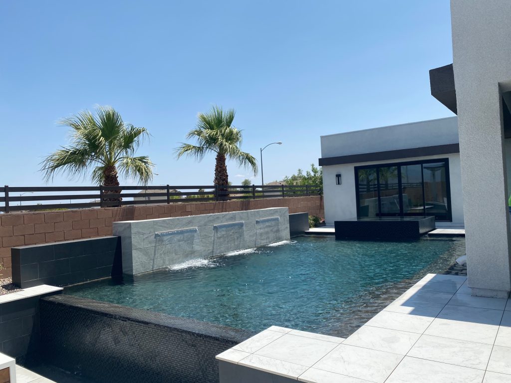 Inspiration for a large modern backyard tile and rectangular pool fountain remodel in Las Vegas