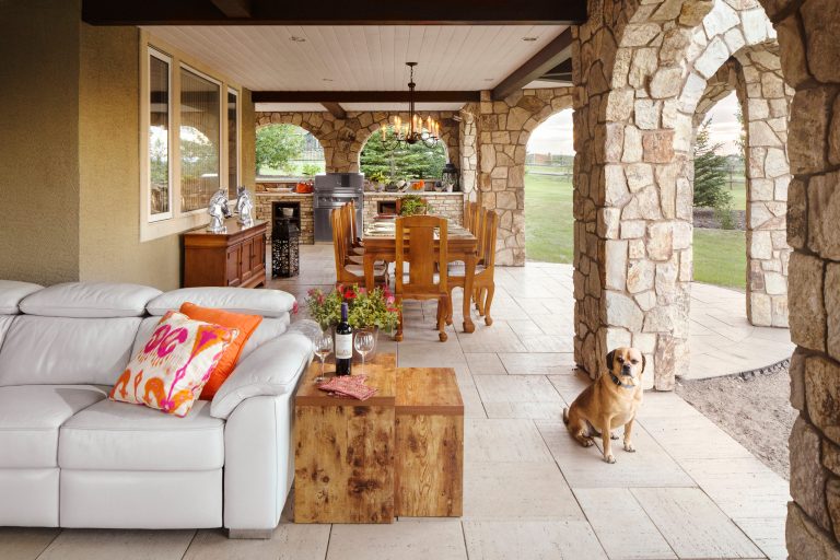 Inspiration for a large rustic backyard stone patio kitchen remodel in Calgary with a roof extension