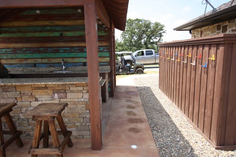 Inspiration for a large rustic backyard stone patio kitchen remodel in New Orleans with a gazebo