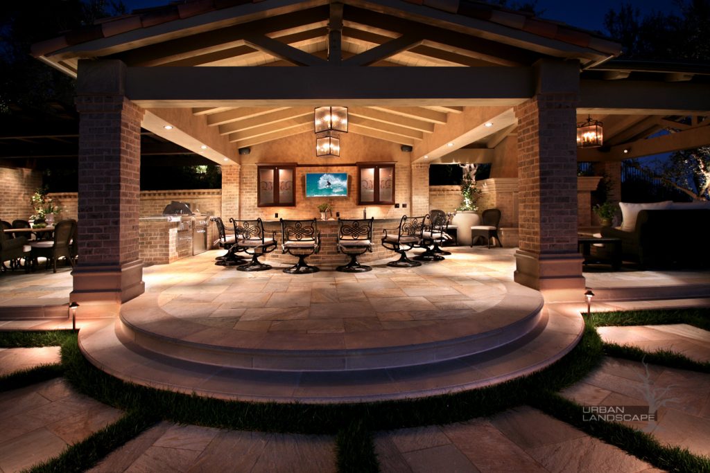 Inspiration for a large timeless backyard brick patio kitchen remodel in Orange County with a pergola