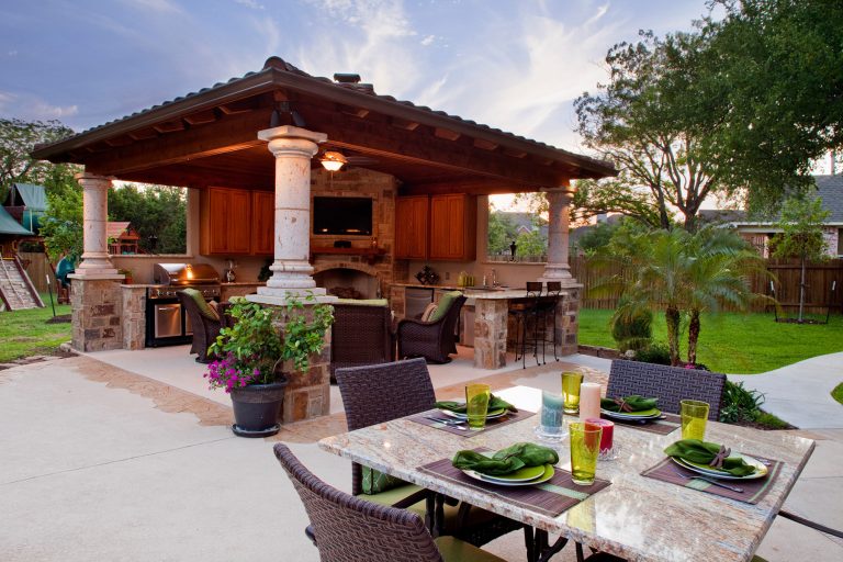 Inspiration for a large timeless backyard concrete patio kitchen remodel in Austin with a pergola