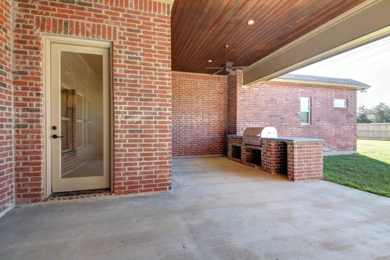 Inspiration for a large timeless backyard concrete patio kitchen remodel in New Orleans with a roof extension