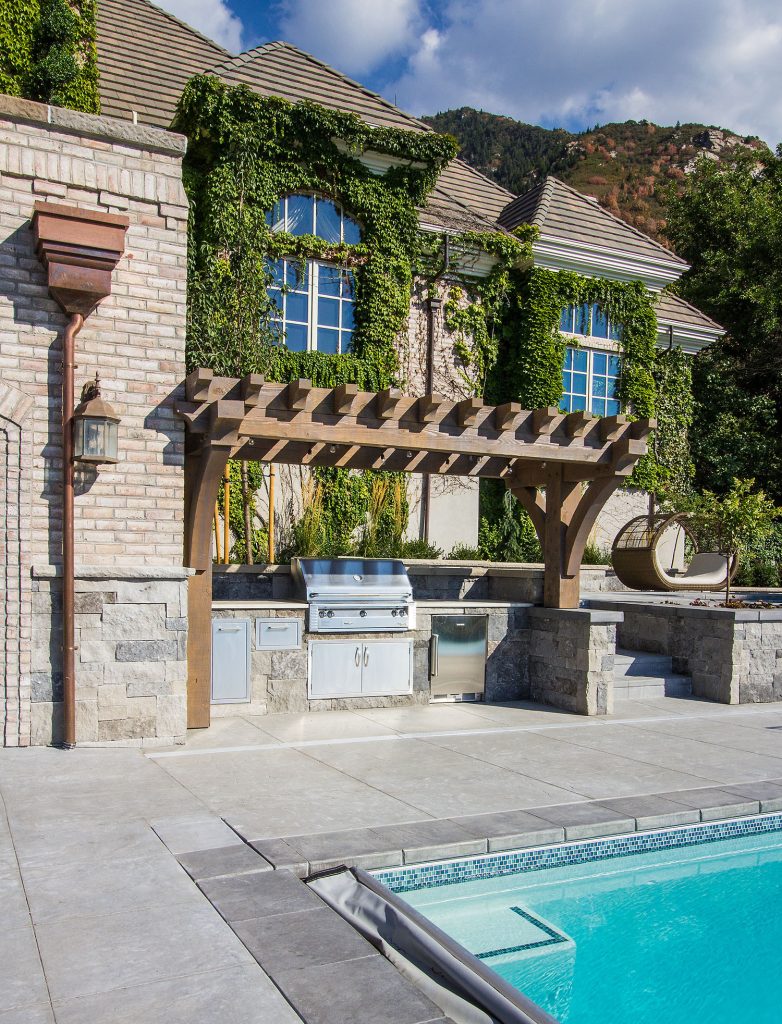 Inspiration for a large timeless backyard concrete patio kitchen remodel in Salt Lake City with a pergola