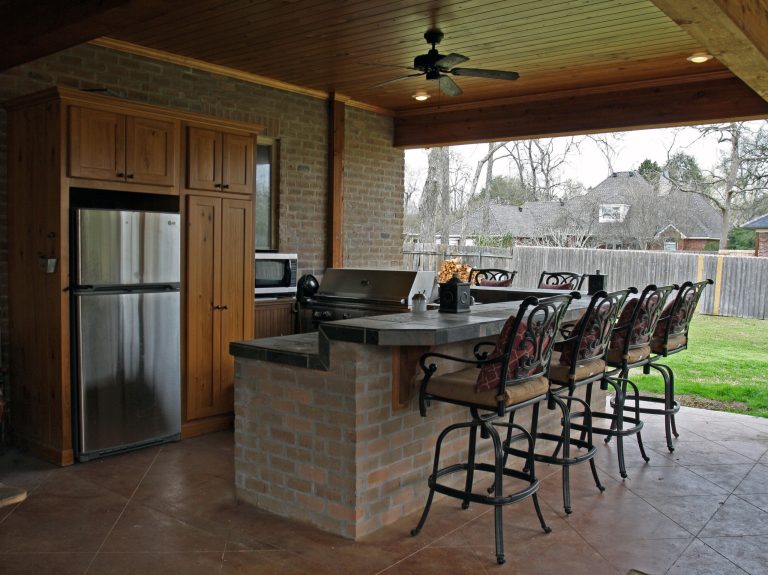 Inspiration for a large timeless backyard concrete paver patio kitchen remodel in New Orleans with a roof extension